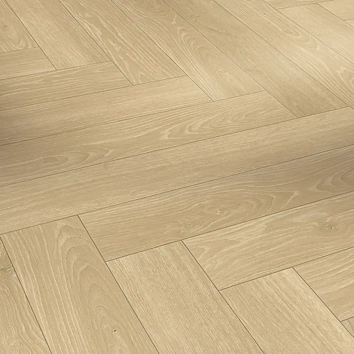 Close-up view of Studioline Natural Herringbone laminate showing its soft oak woodgrain detail and natural matt textured surface.