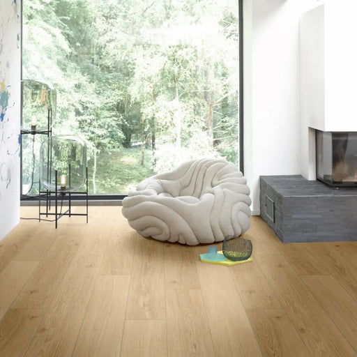 Room scene showcasing Parador Studioline Natural laminate flooring in a wide plank layout, adding warmth and character to a neutral interior.