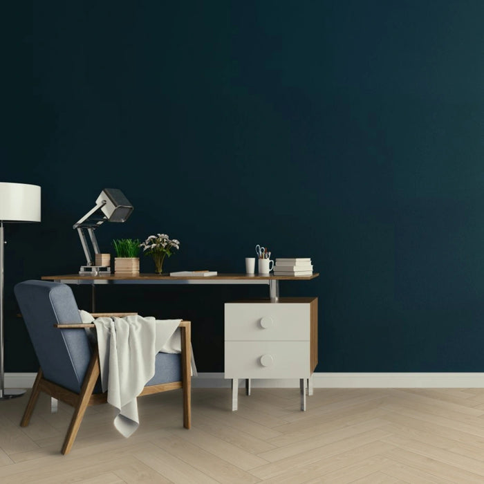 Studioline Sanded Herringbone laminate flooring in a spacious, contemporary room, showcasing its soft oak tones and elegant herringbone layout.