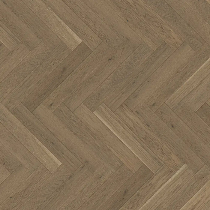 Close-up of Trendtime 3 Nougat Herringbone flooring showing the warm oak tones, fine grain detail, and precisely beveled edges.