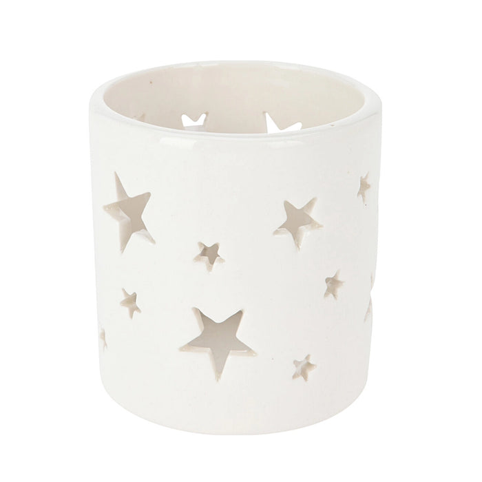 Close-up of white tealight holder showing small star perforations and smooth porcelain finish.