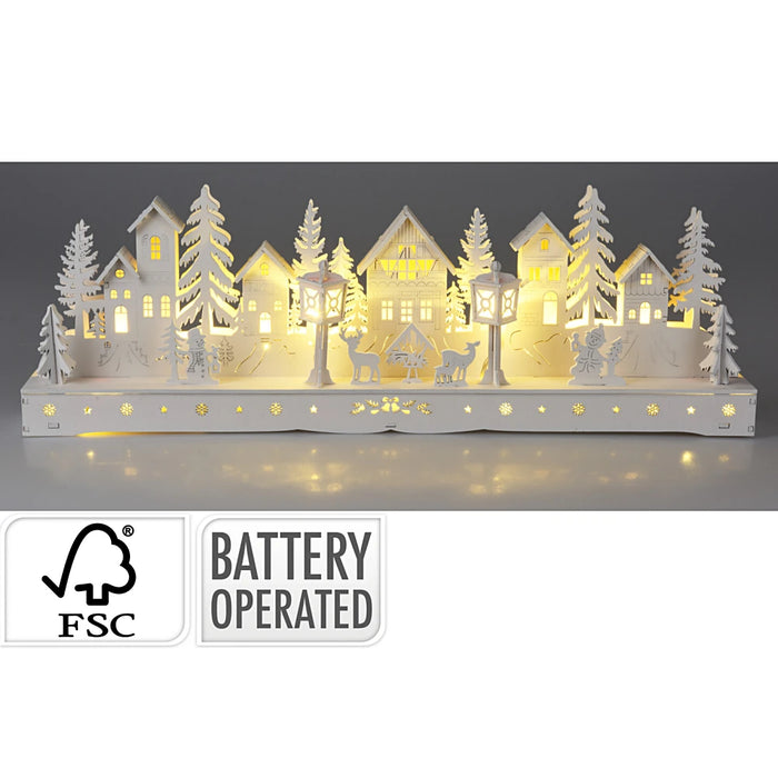 Close-up of White Wooden Village Setting showing detailed building shapes and glowing LEDs.