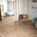 Alicante herringbone laminate flooring in a bedroom with a room divider and armchair