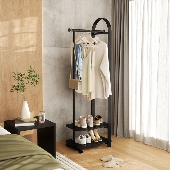 Bellwood black coat rack with clothes in a bedroom setting