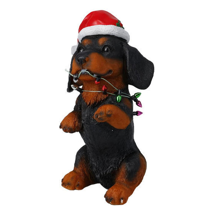 Black and tan dog figure in a Santa hat wrapped in colourful Christmas lights