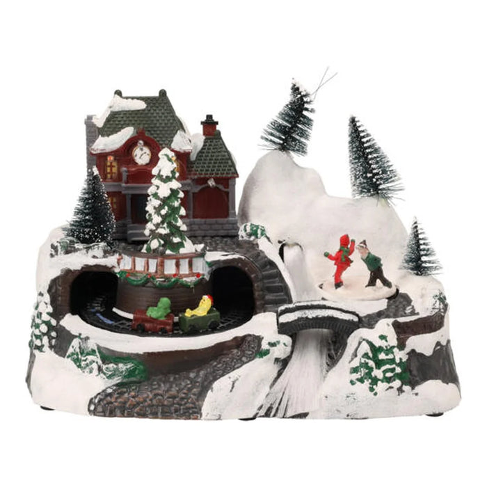 Snowy hillside Christmas scene with a burgundy house, tunnels, a bridge and bottle brush trees