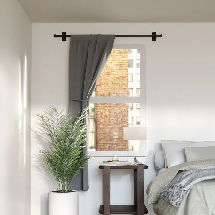 Cappa Adhera matt black curtain pole with curtain in a bedroom setting