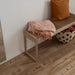 Pergo Drammen Brown laminate flooring in a hallway setting with a wooden bench