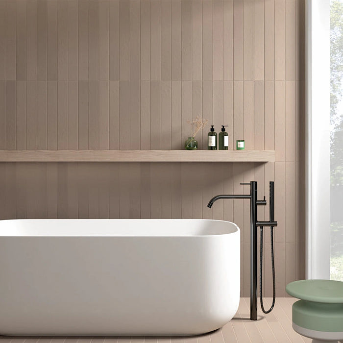 Earth Cashmere porcelain tiles installed vertically on a contemporary bathroom wall with a freestanding bath and natural wood shelf.