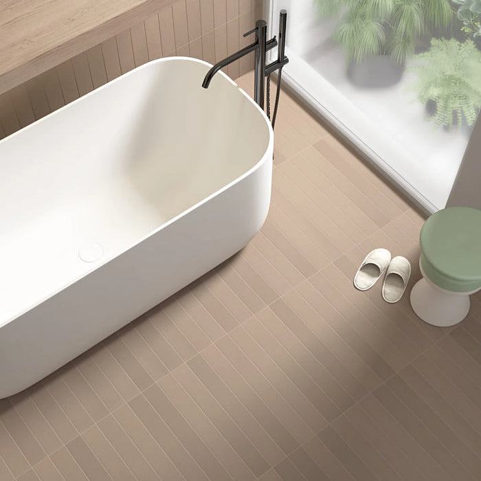 Earth Cashmere porcelain tiles installed on a contemporary bathroom floor in a linear layout with a freestanding bath and matt black fittings.