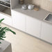 Earth Sand porcelain tiles installed on a contemporary kitchen floor in a linear layout with white cabinetry and a light quartz worktop.