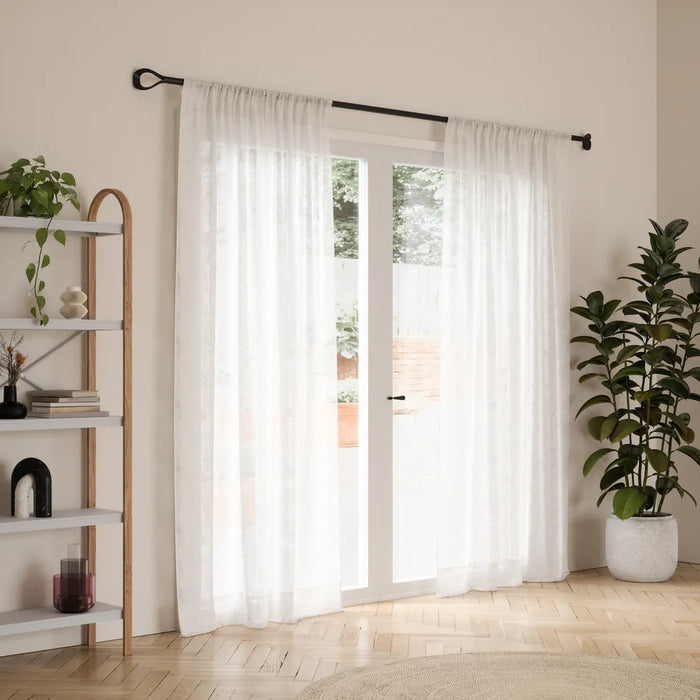 Loop matt black curtain pole with curtain in a living room setting