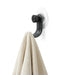 Nami adhesive hook in black colour holding a cream towel