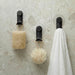 Nami adhesive hooks in black colour on stone tile with loofah, sponge and towel