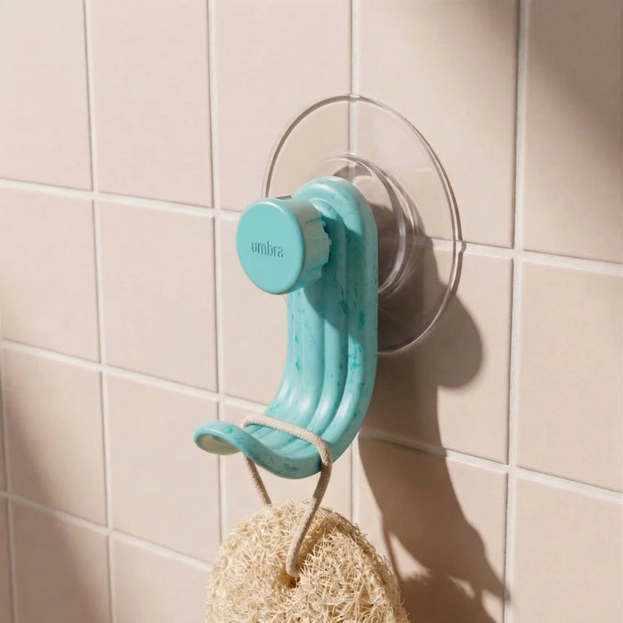 Nami adhesive hook in ocean blue colour on pink tile with loofah
