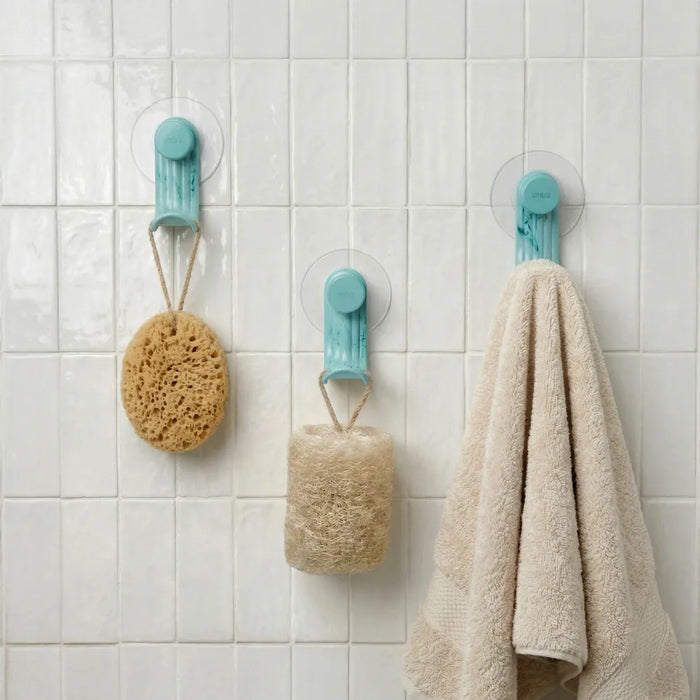 Nami adhesive hooks in ocean blue colour on white tile with sponge, loofah and towel