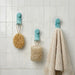 Nami adhesive hooks in ocean blue colour on white tile with sponge, loofah and towel