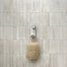 Nami adhesive hook in sand colour on tile wall holding a loofah