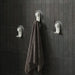 Nami adhesive hooks in sand colour on dark tile wall with towel