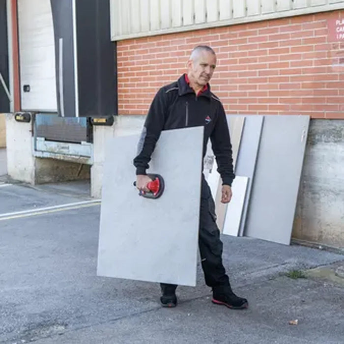 Worker carrying a large format tile slab with Rubi Ellip suction cup