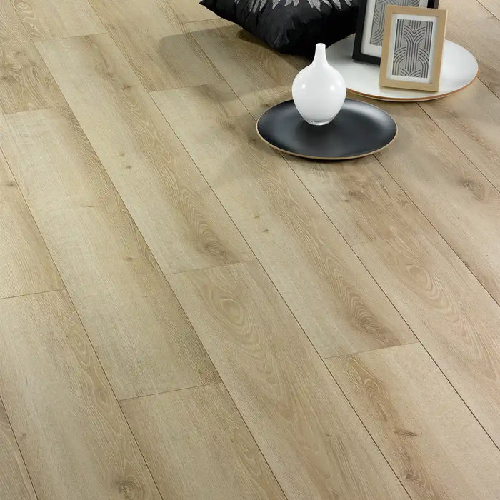 Vicence 12mm laminate flooring styled with a cushion, vase, and picture frames