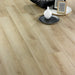 Vicence 12mm laminate flooring styled with a cushion, vase, and picture frames