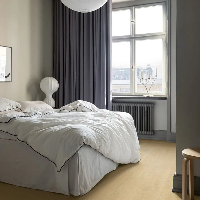 Pergo Visby Sand Drift laminate flooring in a bright bedroom setting