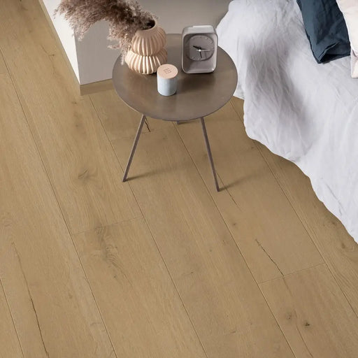 Pergo Visby Driftwood Brown laminate flooring in a bedroom setting with side table