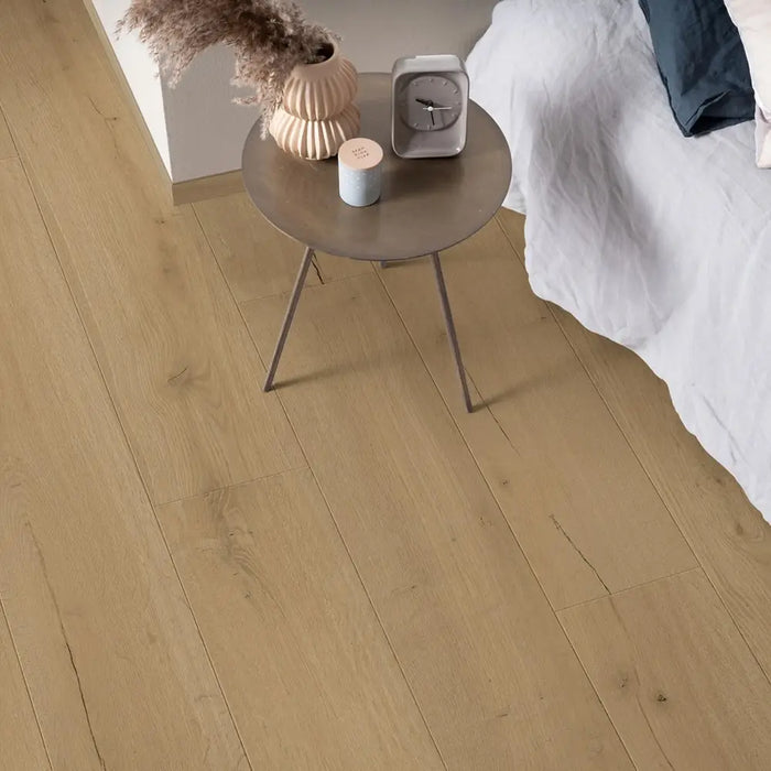 Pergo Visby Driftwood Brown laminate flooring in a bedroom setting with side table