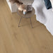 Pergo Visby Driftwood Brown laminate flooring in a bedroom setting with side table