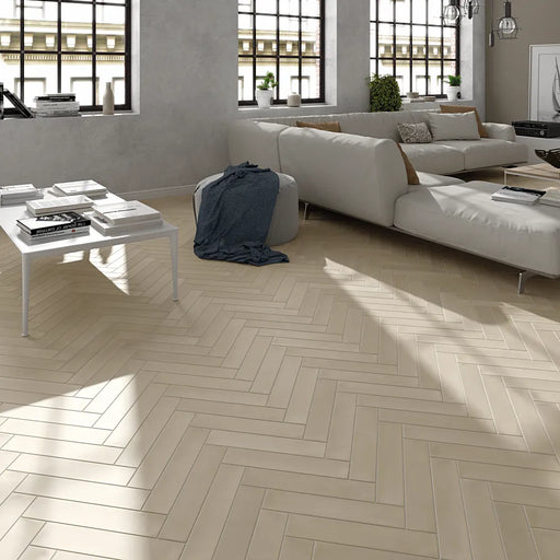 Wadi Beige matt porcelain 6x30 tiles laid in a herringbone pattern in a modern living room