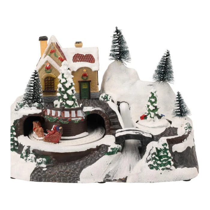 Snowy hillside Christmas scene with a yellow house, tunnels, a bridge and bottle brush trees