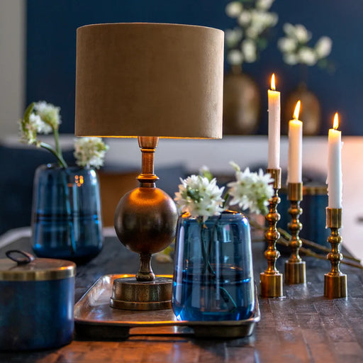 Living room table setting with a lamp, candles and the Ermida glass blue lustre vase