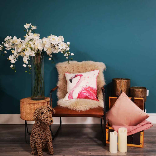 A living room setting with a brown leather chair and Flamant watercolour flamingo cushion
