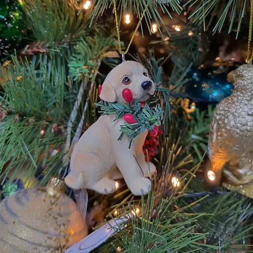 Sitting golden retriever puppy with Christmas wreath hanging decoration
