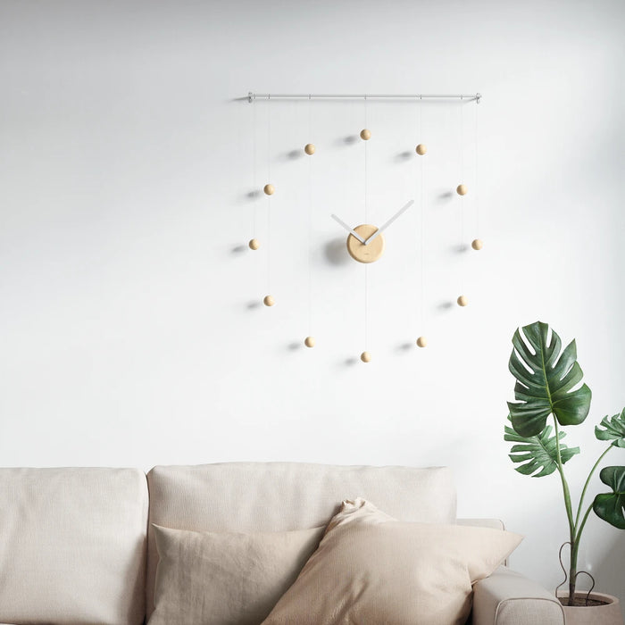 Hangtime wall clock, featuring wooden indicators that hang from its metal bar