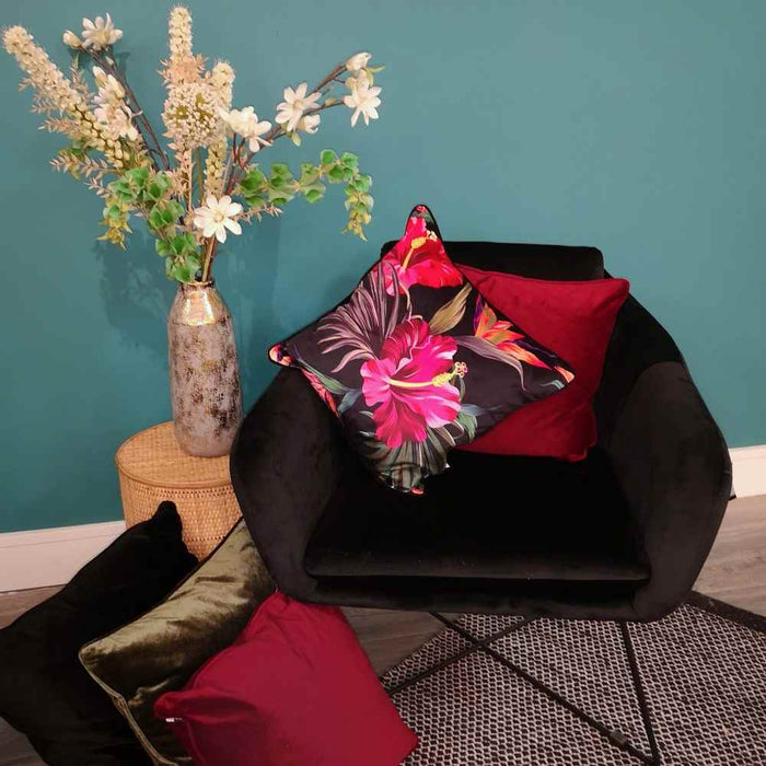 A living room setting with a black occasional seat and Juniper Eden colourful velvet print cushion with a pink hibiscus illustration