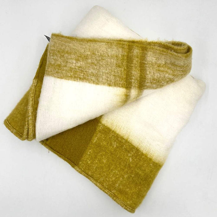 A delicate, snug mustard and white large acrylic throw by Hübsch