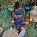 Sitting black Labrador puppy with Christmas wreath hanging decoration