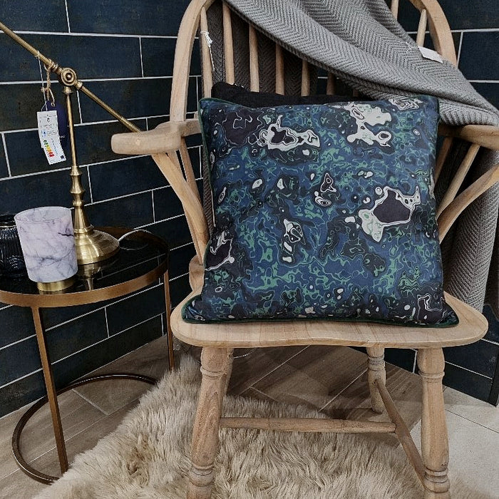 An original graphic distressed marbled design langham cushion in hues of green with a dark green velvet reverse and piping