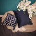 Luxe feather large navy velvet square cushion with piped-edge detailing on a footstool