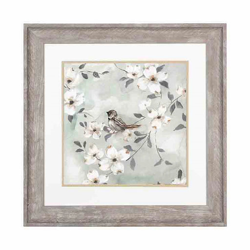 A resting bird among flower covered branches print in an antique white frame