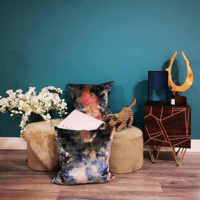 A living room setting with a pouffe and Scatter Box Nisha cushion on lavish cut velvet in a contemporary design with a royal blue velvet reverse