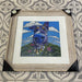 A colourful canine sitting among the flowers print in an antique white frame
